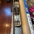 Unboxed drawer slides and mounting hardware laid out in cardboard packaging on a carpeted floor next to hardwood flooring