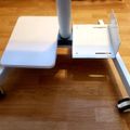 White adjustable laptop stand with arm rest on wooden floor