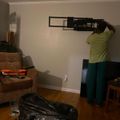 Person installing a TV wall mount bracket on a living room wall