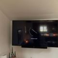 Wall-mounted TV displaying a loading screen with curved progress indicator and date December 29, 2021