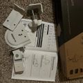 White wall-mounted device with instruction manual and packaging box on carpet floor