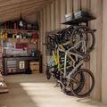 Organized garage interior with bicycles mounted on wall storage rack and workbench with tools and supplies
