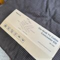 Instruction manual for On-Wall TV Cable Concealer Kit model MI-265 lying on a striped gray couch