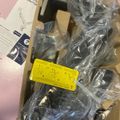 Unboxed counter monitor equipment with plastic wrapping, instruction manual, and yellow warning label in cardboard packaging
