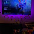 A TV screen displaying the Disney movie Zootopia with animated characters, surrounded by purple ambient lighting and decorative bunny silhouettes hanging below the screen