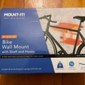 Product box for Mount-It bike wall mount with shelf and hooks, showing a bicycle mounted on an orange wall shelf