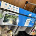TV wall mount package in blue and white box sitting on metal shelving unit
