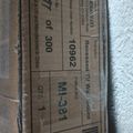 A shipping label or package sticker with barcodes, tracking numbers, and shipping information printed on brown cardboard packaging