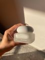 Hand holding a white jar of Hydrating Barrier Cream by 000 parable in natural sunlight