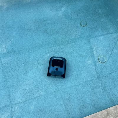 A robotic pool cleaner operating on the bottom of a swimming pool