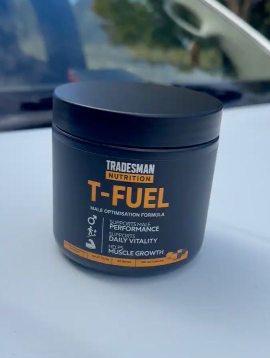 Black cylindrical supplement container labeled Tradesman Nutrition T-Fuel Male Optimization Formula sitting on white surface