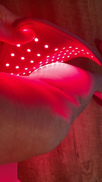Novaa Light Pad wrapped around a knee emitting red light
