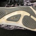 Bottom view of a camouflage patterned sneaker showing the sole with "petuva" branding and tread pattern