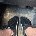 Person wearing black toe shoes with individual toe compartments standing on a concrete floor