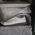 White athletic sneaker in an open shoebox with tissue paper packaging