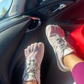 Person wearing toe shoes with individual toe compartments sitting in a car with red interior
