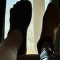 Person's feet resting by a window with natural light coming through
