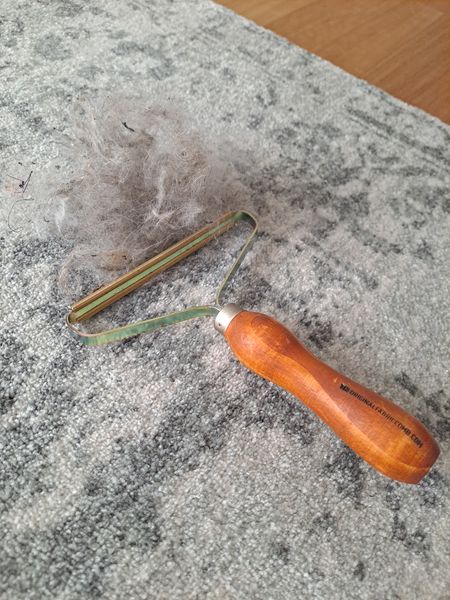 Hidden cat hair lifted from a living room rug using an EEZY Fabric Comb