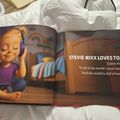 A children's book page showing a young child with blonde hair wearing purple headphones and sitting cross-legged, with text about Stevie Nixx loving to listen