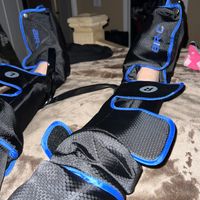 Customer-uploaded image. Click to see more details. The image represents: Person wearing black and blue protective gear or braces on their legs while sitting on a bed