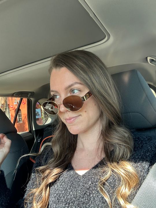 Woman wearing sunglasses sitting in a car interior