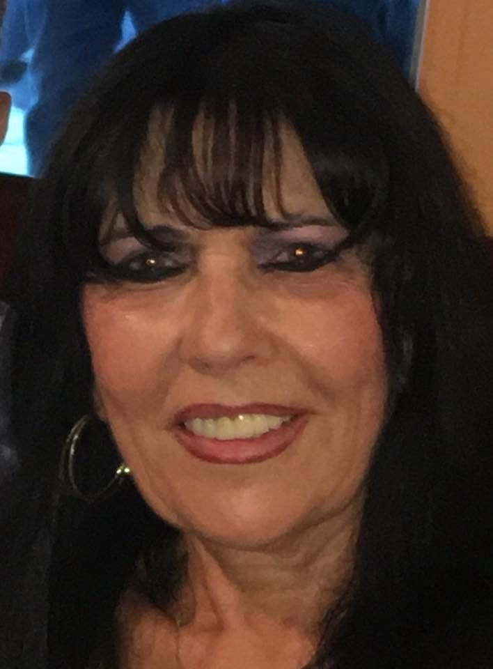 Woman with dark hair and bangs smiling at camera